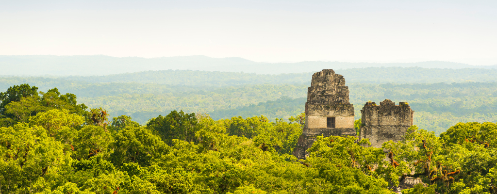 ## Discover Tikal and the Mayan World

Traveling through Guatemala is a constant discovery of dazzling nature, incredible beauty, culture, and history. You find all this in wonderful destinations such as Lake Atitlán, or Antigua Guatemala, but it blends in a special way when you visit Tikal and the heart of the Mayan world. 

Tikal is located in Peten, Guatemala, home to one of the most important rainforests in the Americas and the most important Mayan legacy on planet earth. The first thing you will notice when you enter this region of Guatemala is that it is covered with dense rainforest everywhere you look. This is really special because when you arrive to Tikal, Yahxá, or any Mayan ruin you visit, you will find a natural and wild scenery, along with Mayan structures with more than a thousand years of history.

![Discover Tikal and the Mayan world (3).png](https://cdn.travelisimo.com/Descubre_Tikal_y_el_mundo_maya_3_906c27af43)

## Tikal National Park
Without a doubt Tikal is one of the places you have to visit in Guatemala. The Mayan ruins and ceremonial temples that this park houses and the nature that surrounds it is truly impressive. That's why Tikal National Park is considered a world heritage site by UNESCO.

Tikal is located in the north of Guatemala, 45 minutes by car from the island of Flores, 40 minutes from the Mundo Maya Airport, and 1 hour from San Ignacio, Belize. These are commonly the places that people take as a base for lodging, food and shopping when visiting Tikal. The reality is that the park is located in the middle of the jungle, literally, so although there are hotels inside the park, the vast majority of tourists seek to start from Flores or San Ignacio. 

Currently, Tikal is an archeological site of great importance for Guatemala and for the Mayan history. However, at the time, Tikal was the most important city that the Mayas had in the region, practically building an advanced civilization with political, religious and social systems. 

Tikal dates back to 1000 BC, but it is estimated that its origins date back to the fourth century BC. Over the centuries, what was once a great city was hidden beneath the jungle of Guatemala. It was not until the middle of the 19th century that excavation work began to recover the Mayan legacy of the site. And it was from that date that Tikal was declared a national park and has been promoted as a cultural, historical and tourist vestige for humanity. 

![Discover Tikal and the Mayan world.png](https://cdn.travelisimo.com/Descubre_Tikal_y_el_mundo_maya_e59a77eb8e)

## When should you visit visit Tikal?

One thing you should know about Tikal, and in general about all the nearby archaeological sites, is that they are outdoors. You will be walking under trees hundreds of years old, and roads completely immersed in a tropical jungle. So the climate is a very important variable to take into account when visiting this destination. 

In Guatemala there are primarily two seasons: the rainy season (winter) and the dry season (summer). The first generally lasts from May to October each year, and is a difficult time to visit Tikal. The rains start around noon and can last for several hours. So if you are outdoors, in a jungle, and without a rain shelter, it may be a less than pleasant experience. 

Now the dry season in Guatemala is not as hot as in other parts of the tropics, but just in the northern part of Guatemala the story is different. In this part of the country the heat is intense, and being in a tropical zone the thermal sensation is even more intense. However, that doesn't mean you won't enjoy your visit, but you will definitely be sweating a lot during the whole visit. 

So when is the best time to visit Tikal? It is definitely during January, February and March. It's just between the rainy season and the dry season in Guatemala, and it is also a time when there is not a large influx of tourists. So the experience can be enjoyed even more. 

![Discover Tikal and the Mayan world (4).png](https://cdn.travelisimo.com/Descubre_Tikal_y_el_mundo_maya_4_e723fcf761)
*Upon arrival, you will find ruins more than 47 meters high.*

## What else to visit besides Tikal?

When you arrive in Tikal you will see that there are other famous reserves and attractions relatively close to where you are. These destinations are usually not as well known or marketed to foreigners, so you may not have heard of them. However, they are almost, if not quite as impressive as Tikal. 

- #### Yahxá National Park 

Yahxá Park is located very close to the Belize border, between the island of Flores and  Melchor de Mencos Border. As with Tikal, you can reach the park from Flores or from San Ignacio, Belize. This park was once the capital of an extensive Mayan domain over the region, with pyramidal temples, epic urbanizations, palaces for rulers and religious temples. 

The park is truly beautiful because it allows you to appreciate a delicate balance between nature, with its lagoons, wetlands and rainforest. And at the same time a pre-Hispanic cultural heritage that remains as a memory of what was once the great Mayan power. 
In addition, Yaxhá is considered one of the most beautiful sunsets in all of Central America.

![Discover Tikal and the world - Central America Journal (2).png](https://cdn.travelisimo.com/Descubre_Tikal_y_el_mundo_Diario_de_Centro_America_2_d6b3cd9f70)

- #### Crater Azul

Crater Azul in Petén is one of the least known tourist destinations by the general public. However, thanks to videos on social networks, like TikTok or Instagram, this destination has taken a great popularity among young people and backpackers who enjoy a unique destination in Guatemala.

This "crater" is more like a turquoise lagoon that connects with the La Pasión river, which allows an underwater garden to grow and beautify the landscape in a spectacular way. Visiting this tourist destination you will realize that the river tour is a worthwhile experience in itself, with birds, monkeys, lizards and other wildlife seen in their natural habitat. 

![Fotos blogs 2 (1).png](https://cdn.travelisimo.com/Fotos_blogs_2_1_92b87f48ce)
##### Créditos: Banco Industrial de Guatemala

- #### Flores Island

Flores Island is a picturesque island at the head of Petén. It could be said that it is the capital of the state or department of Petén, so besides being an important tourist site it is also one of the closest cities to parks like Tikal or Yahxá.

That is why most tourists visiting Tikal and the Mayan world stay in hotels or hostels located in Flores. In addition, it has become a colorful town with fun bars, hostels and entertainment centers. And it is recognized for having a wide gastronomic variety within the island. 

![Discover Tikal and the world - Diario de Centro América.png](https://cdn.travelisimo.com/Descubre_Tikal_y_el_mundo_Diario_de_Centro_America_7a2ba1e771)
##### Créditos: Diario de Centro América

- - - 

If you are planning or would like to visit Tikal and the Mayan world, contact us, and we will support you in the whole process of booking your trip.
