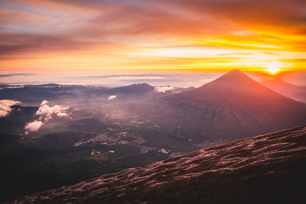 In Guatemala there are approximately 288 volcanoes or structures of volcanic origin. Only 8 of these have activity reports in historical times and 3 are the most active today. Even so, 37 are officially recognized as volcanoes by the National Federation of Mountaineering. Instead, the National Geographic Institute recognizes 32.

 

## Acatenango Volcano

The Acatenango volcano is part of the volcanic chain that exists in the Republic of Guatemala. The volcano is extinct, it no longer presents activity that involves lava eruptions. It has a height of 3976 meters above sea level. The view towards the Fuego volcano is spectacular, since it is the best setting.

![Volcán Acatenango Erupción.jpg](https://cdn.travelisimo.com/Volcan_Acatenango_Erupcion_9ed054d0e5)

## A water volcano

An iconic volcano giving life to the landscape of Antigua Guatemala, from the top; At the top you will find an abandoned helicopter with more than 10 years. This beautiful volcano has a height of 3766 meters above sea level and is classified as one of the highest in Guatemala. It takes approximately 4 to 5 hours to climb it from Santa María de Jesús. You can also go up by vehicle, since there is a specialized route, this beautiful volcano is visible from the capital city.

![Volcán de Agua, Sacatepequez.jpg](https://cdn.travelisimo.com/Volcan_de_Agua_Sacatepequez_ebeddb4e0f)

## Ipala Volcano

The Ipala volcano and lagoon are beautiful Guatemalan tourist attractions located between Chiquimula and Jutiapa. Every day it is visited by dozens of Guatemalans and foreigners, looking for a moment of peace in the nature of the beautiful formation. The Ipala volcano and lagoon are part of an area protected by CONAP, with the aim of conserving the natural features of the flora and fauna of the place.

![Volcán Ipala.jpg](https://cdn.travelisimo.com/Volcan_Ipala_4c8c5dfe62)
 
## Santo Tomas Volcano

In search of a good view, surely this volcano is a very good option. At 3505 meters above sea level, the Santo Tomás Volcano is located between the departments of Quetzaltenango and Sololá. To ascend it takes approximately 6 hours and 4 hours to descend. It is populated by many forests with deep ravines on the east and west sides.

![Volcan Santo Tomas.jpg](https://cdn.travelisimo.com/Volcan_Santo_Tomas_ea95d49ff5)

## Pacaya Volcano

The Pacaya Volcano is located in the municipality of San Vicente Pacaya, in the department of Escuintla, in the southern part of the Republic of Guatemala. This volcano is listed as a national park. Its height has changed due to constant eruptions, 2,500 meters above sea level have been recorded. It first erupted about 25,000 years ago and reactivated in 1996, after nearly a century of inactivity.

![Volcan Pacaya.jpg](https://cdn.travelisimo.com/Volcan_Pacaya_796fd6490d)