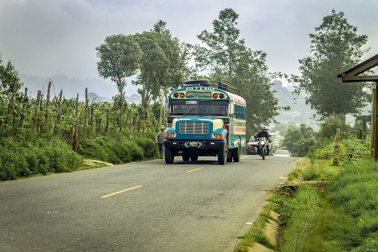 ## General information
It is easy to get around Guatemala: there is no lack of old school buses or "micros" on its roads, you never expect a lot to pass and it is cheap $1.50 to $2. If you are looking for direct transport, door to door, there are no shortage of offers aimed at tourists, but these shuttles are much more expensive and you miss the trip locally.

## Buses in Guatemala
It is the usual way to move around Guatemala, in general it is easy and cheap. There are regional differences regarding the type of bus. What is most abundant, especially throughout the south of the country, are old school-type buses, well maintained and modified on the outside. Only in some sections are they saturated with people and that is when you have to share a seat between 3 people, but in general you travel quite comfortable.

If you travel with small luggage, you carry it in the upper luggage racks (but always keep an eye on it), people leave their belongings there with peace of mind. Otherwise they go in the back or up on the outside.


![Diseño sin título(12).png](https://cdn.travelisimo.com/Diseno_sin_titulo_12_bdc3642974)

Quite new "coasters" (minibuses) and "micros" (Toyota vans) circulate mainly in the Alta Verapaz area (Cobán, Lanquín) and Petén. Between rural towns and on unpaved roads, it is common to move around in pick-up trucks, directly in the box, standing up without seats. It is used in specific destinations such as to go from Lanquín to Semuc Champey

They travel quite fast even though they often stop to pick up more people (on average about 50km /h).

![44.png](https://cdn.travelisimo.com/44_6b719f66ea)

## Guatemala bus price
Cheap transportation, Q10 to Q15 ($1.50 to $2.00) on average in main sections.

The cost of transportation in Peten rises, but always looking to consult different sites can give you the idea of the fair payment. This is not the case in the rest of Guatemala, travelers pay the right price, in general it is not written on the bus (in case of doubt, ask a passenger)

There is a lot of frequency between the main cities and towns of Guatemala (in general there is a bus leaving every 15-30 min). There are not always direct buses between tourist spots, such as between Antigua and Chichicastenango or Panajachel, but the transfers are quick, getting off at the crossroads (never wait more than 5 minutes).

The buses carry the names of the cities written, it is convenient to read them to be clear about the destination. The names of the cities to visit are written on top of the windshield.

## Guatemala bus safety
In general, it is safe to use public transport, but it is true that some routes that lead to Guatemala City (especially east of the capital) and urban routes on the capital's red buses have histories of robberies.

It is very rare that something happens on the buses that travelers use!

## Pullman type bus in Guatemala
They are companies that connect the main cities of the country on long routes, with more modern style buses, although not always very new (there are usually different categories and prices in many cases). In general, they are not used much in the south of the country: they are more expensive and not faster than van-type (school) buses.

But they are the usual way to travel between Guatemala City and Cobán or Guatemala City and Santa Elena (Flores), in this case with night buses. They usually have specific departure times.

Pullman companies: Línea Dorada, Fuente del Norte, Monja Blanca (Cobán), etc.

Many of them have private websites and terminals. You can even buy online. It would be the most "modern" transportation in Guatemala.

![42.png](https://cdn.travelisimo.com/42_e19b922cbf)

## Bus Stations
The "terminals" are usually a wasteland and are often located next to a market area. We don't want to imagine what it will be like when it rains, with the people who move through Guatemala every day, with their baskets and luggage.

There are usually no waiting chairs, or a shed, or offices, it is best to consult a local about the route you want to take to have a clear idea of what to take and where to wait specifically.


![43.png](https://cdn.travelisimo.com/43_ffed90765a)

## Tourist shuttles
It is the most used transport by most tourists who visit Guatemala. They directly connect the main tourist destinations: Guatemala airport, Antigua, Panajachel (also San Pedro), Chichicastenango, Lanquín / Semuc Champey, Río Dulce, Flores, Tikal. There are also shuttles that connect with Mexico (Palenque, San Cristóbal), Honduras (Copán) and El Salvador.

Ideally, you will find an offer that suits the destination you want to visit, normally it is used as direct transport to the destination, but taking into account that it is not always the most comfortable option for long hours of travel. In general, trips are between $ 10-20!

![Diseño sin título(1).png](https://cdn.travelisimo.com/Diseno_sin_titulo_1_07f955db17)

## International routes
There are connections between Guatemala and the rest of the Central American countries and Mexico. They are often very long routes, lasting several days in many cases. There are more and more international companies. TICA BUS, passes through all of Central America from Panama to Mexico. Platinum, Hedman Alas, etc. Most companies have websites. It is much cheaper to take local buses, on either side of the border.

![Diseño sin título(2).png](https://cdn.travelisimo.com/Diseno_sin_titulo_2_6057387301)

## Roads in Guatemala
Guatemala's main highways are generally normal, although it varies greatly from region to region. From unfolded highways such as the one that goes from Guatemala City to Xela or the one that goes down to the coast from the capital (the latter with a toll) or the one that goes to the Caribbean that is in expansion works. There is a lot of traffic, especially trucks and buses, on the main route that crosses the country (Guatemala City-Xela) and the descent to the coast.

![45.png](https://cdn.travelisimo.com/45_cbffc541ae)

## Boats
These are boats mainly on Lake Atitlán (they connect towns such as Panajachel, Santiago, San Marcos, San Pedro, for about Q25-4 $) and the tourist stretch from Río Dulce to Livingston (the price is expensive, Q125-18 $ for a 1h30 ride!). There is also a ferry from Puerto Barrios to Livingston, cheaper to reach this Caribbean town. The boats that connect Livingston with Belize (Punta Gorda) are expensive: $ 25.

![48.png](https://cdn.travelisimo.com/48_4d6e6c2c72)

## Flight
Flights in Guatemala are concentrated at the Aurora International Airport. There are flights to other cities in America and Europe, although fares are often cheaper to neighboring Mexico or El Salvador. There are several low-costs that operate between Guatemala and Mexico, as well as Costa Rica and the USA. Volaris, Interjet, Spirit Airlines.

Domestic flights are limited to the route between the capital and Flores (Petén, to visit the Mayan ruins of Tikal), also between the city and Huehuetenango. These flights don't usually go below $ 100-120. The main company is Avianca, but also Tropic Air and TAG.


![49.png](https://cdn.travelisimo.com/49_3545c382cf)

## Car rental
It is not very common since there is public transport to almost all places in Guatemala and it is cheap. But if you want more comfort when traveling with family or friends and deciding your destination on the go will undoubtedly be your best option, you can visit our Car rental section to see the best options today.

![50.png](https://cdn.travelisimo.com/50_7e3b040191)

## Tuc Tuc
The tuc-tuc are a very common transport in the interior of the country, an ideal means of transport for visitors who like to experience the reality of the country up close and be part of the day-to-day life of Guatemala; The costs are variable but an approximate estimate in the range is from Q10 to Q50 depending on the distance you need to travel, you can obtain information on them at the Municipalities or the information centers at the destinations or at the reception of your hotel.

![51.png](https://cdn.travelisimo.com/51_8cf6c662dd)

## Taxi
There are two types of taxis in Guatemala City, the yellow ones and the white ones; The recommendation is that you can move if necessary in the moorings where you can schedule your transfer to your destination and have all the information on costs and schedules on their official website.

We also have Uber in Guate.

![Diseño sin título(3).png](https://cdn.travelisimo.com/Diseno_sin_titulo_3_8d80cb1807)