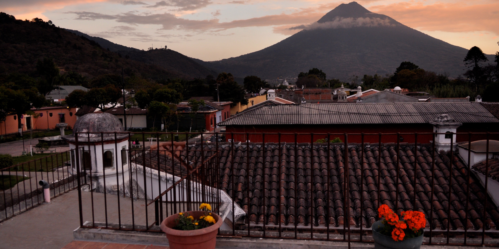 Antigua Guatemala is a must-see destination for any traveler looking to experience the best that Guatemala has to offer. With its charming colonial architecture, impressive volcanoes, rich cultural history, delicious food, vibrant nightlife and beautiful natural surroundings, there are countless reasons to visit this beautiful city.

![photo-body-blog-antique.png](https://cdn.travelisimo.com/foto_cuerpo_blog_antigua_09ffa9e4e2)
##### Credits: Photograph of the Arch of Antigua Guatemala
---

## Why Antigua?

One of the main reasons to visit Antigua Guatemala is to marvel at the charming colonial architecture. The city is known for its beautiful Spanish colonial buildings, with their colorful facades, cobblestone streets and charming plazas. Take a stroll through the historic center and admire the impressive architecture, including the iconic Iglesia de La Merced and the Palacio de los Capitanes Generales. 

Another reason to visit Antigua Guatemala is to experience the impressive volcanoes that surround the city. With three volcanoes, Agua, Fuego and Acatenango, in close proximity, there are plenty of opportunities for breathtaking hikes and panoramic views. Whether you are an experienced hiker or just looking for a unique experience, a [volcano hike](https://travelisimo.com/es/guatemala/actividades/tours-y-experiencias/antigua-guatemala/explore-and-walk-in-acatenango-volcano-2?country=GT&) in Antigua is not to be missed.

###### Use the code **ANTIGUATOUR** to get a 10% discount on the purchase of tours of the colonial city of Antigua Guatemala

![photo-body-blog-antigua-volcano.png](https://cdn.travelisimo.com/foto_cuerpo_blog_antigua_volcan_894a1c756c)
##### Credits: Photograph of Agua Volcano, Antigua Guatemala

---

## Other points in Antigua's favor

Antigua Guatemala's rich cultural history is another reason to visit this beautiful city. As the former capital of Guatemala, Antigua has a rich history dating back to the 16th century. To learn more about the city's history and culture, visit the Museo de Santiago or take a tour of the historic monuments.

Food lovers will love the delicious food that can be found in Antigua Guatemala. From traditional Guatemalan dishes like pepián (a spicy meat stew) and tamales, to international cuisine, there is something for everyone to enjoy. Be sure to try some local specialties and experience [Antigua's culinary delights](https://travelisimo.com/es/guatemala/actividades/tours-y-experiencias/antigua-guatemala/explore-and-taste-traditional-guatemalan-foods?country=GT&). 

If you love to party, Antigua Guatemala is the perfect destination for you. The city has a vibrant nightlife, with a wide range of bars and nightclubs offering live music, dancing and a fun atmosphere. Head to one of the local bars or clubs and experience Antigua's lively nightlife.

![photo-body-blog-antigua-bar-food.png](https://cdn.travelisimo.com/foto_cuerpo_blog_antigua_bar_comida_5cbba45506)
##### Credits: Photo left side a plate of pepián and on the right side the Lava Terrace bar. 

---

## Colonial architecture and nature

Finally, the breathtaking natural beauty of Antigua Guatemala is another reason to visit this beautiful city. In addition to the impressive volcanoes, Antigua is surrounded by beautiful natural scenery, including lush forests, green fields and picturesque landscapes. Take a walk in the countryside or visit one of the nearby nature reserves and experience the beauty of Antigua's natural environment.

Overall, there are countless reasons to visit Antigua Guatemala. From its charming colonial architecture and impressive volcanoes, to its rich cultural history, delicious food, vibrant nightlife and beautiful natural surroundings, **Antigua is a must-see destination** for any traveler looking to experience the best of Guatemala.

###### Remember to use the code **ANTIGUATOUR** to get a 10% discount on the purchase of tours to this colorful and colonial destination in Guatemala.

![photo-body-blog-antique-beauty.png](https://cdn.travelisimo.com/foto_cuerpo_blog_antigua_belleza_2c6cca5331)
##### Credits: Photograph of Cerro de la Cruz, Antigua Guatemala.

---


Discover all that Antigua Guatemala has to offer and plan your trip to this colorful destination with **Travelisimo**.

