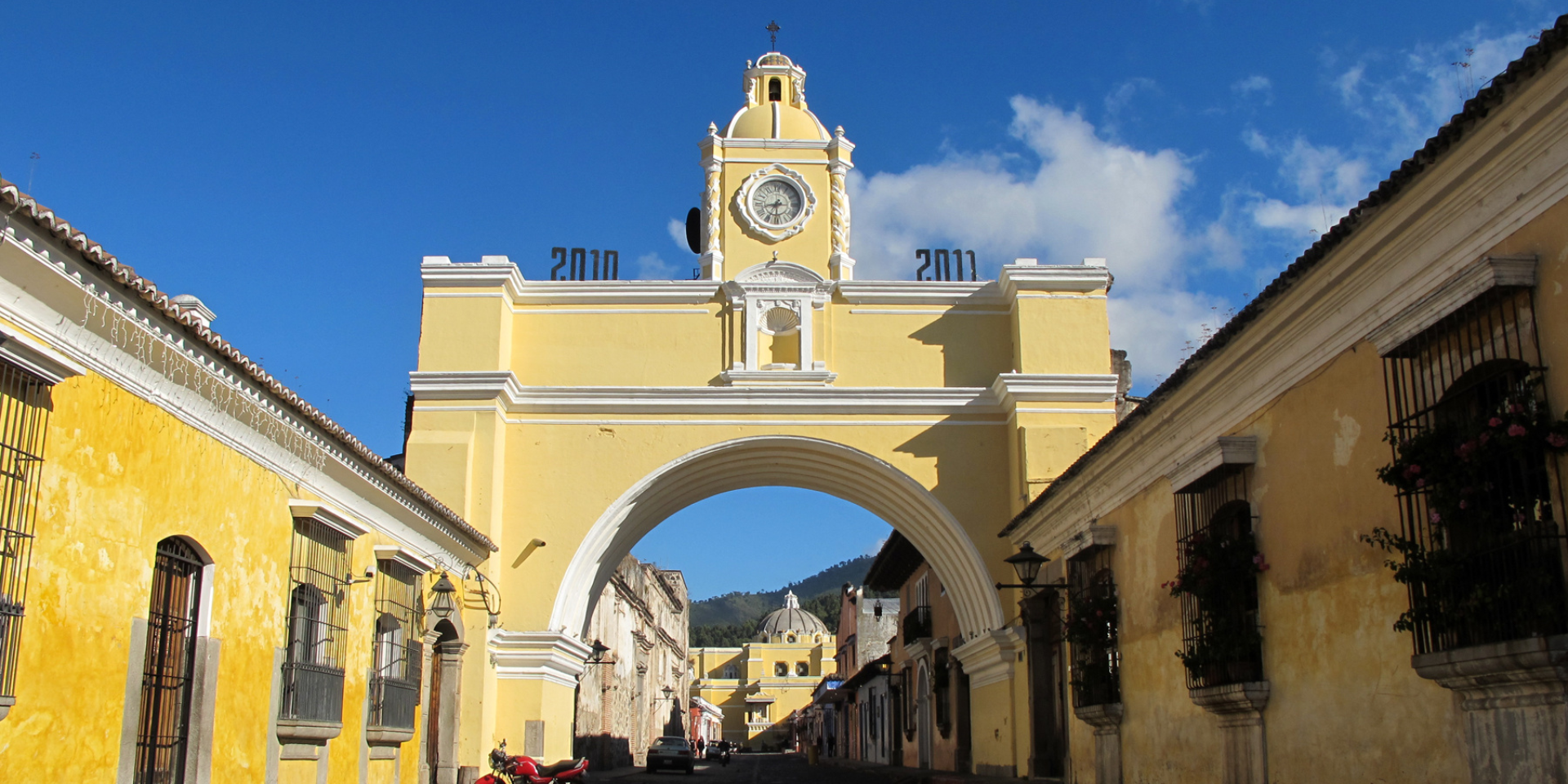 Antigua Guatemala es un destino muy popular entre los viajeros a Guatemala, por su encantadora arquitectura colonial, sus impresionantes volcanes y su rica historia cultural. Si está planeando visitar Antigua, necesitará saber cómo llegar del aeropuerto a la ciudad. En esta entrada del blog, vamos a proporcionarte información sobre las diferentes opciones de transporte disponibles, incluyendo estimaciones de tiempo y consideraciones de presupuesto.


![foto-cuerpo-blog-traslado-aeropuerto.png](https://cdn.travelisimo.com/foto_cuerpo_blog_traslado_aeropuerto_1f93b8441e)
##### Créditos: Fotografía del Aeropuerto Internacional Aurora

---
## Tiempo estimado

La distancia entre el Aeropuerto Internacional de Guatemala y Antigua es de unos 35 kilómetros (22 millas), lo que lleva entre 45 minutos y 1 hora en coche, dependiendo del tráfico.

## Opciones de transporte

Hay varias opciones de transporte disponibles para ir del aeropuerto a Antigua, incluyendo lanzaderas, taxis y transporte privado.

- **Lanzaderas:** Los servicios de lanzadera son una opción popular para los viajeros a Antigua, ya que ofrecen una forma cómoda y económica de llegar a la ciudad. La mayoría de los servicios de lanzadera ofrecen un servicio de puerta a puerta y pueden acomodar a grupos de todos los tamaños. Los precios varían según la compañía y el número de pasajeros, pero se puede esperar pagar entre 15 y 30 dólares por persona.

- **Taxis:** Los taxis son fáciles de conseguir en el aeropuerto, y se puede solicitar un taxi privado o llamar a uno en la parada de taxis. Los precios de un taxi privado a Antigua varían en función de la compañía, pero el viaje puede costar entre 50 y 60 dólares. Ten en cuenta que los precios son negociables, por lo que conviene acordar la tarifa antes de iniciar el viaje.

- **Transporte privado:** Si prefieres una experiencia más personalizada, también puedes contratar transporte privado a Antigua. Esta opción suele ser más cara que las lanzaderas o los taxis, pero ofrece un mayor nivel de confort y comodidad. Los precios varían según la compañía y el tipo de vehículo que elijas.


![foto-cuerpo-blog-traslado-buses-privados.png](https://cdn.travelisimo.com/foto_cuerpo_blog_traslado_buses_privados_a85cc2b7c4)
##### Créditos: Fotografía de buses privados.

---
## Consideraciones presupuestarias

A la hora de decidir tu opción de transporte, conviene tener en cuenta su presupuesto y sus necesidades de viaje. Los servicios de lanzadera y los taxis suelen ser las opciones más asequibles, mientras que el transporte privado suele ser más caro. Ten en cuenta que los precios pueden variar según la época del año y la demanda de transporte.

## ¿Por qué son más recomendables las lanzaderas o el transporte privado?

Aunque los taxis son una opción cómoda, las lanzaderas y el transporte privado ofrecen algunas ventajas que pueden hacer que sean una mejor opción para algunos viajeros. Por ejemplo, las lanzaderas suelen ofrecer un servicio más organizado y eficiente, con múltiples recogidas y dejadas a lo largo del trayecto. El transporte privado, por su parte, ofrece una experiencia más personalizada, con la flexibilidad de personalizar su itinerario y viajar a su propio ritmo.

![foto-cuerpo-blog-traslado-lanzaderas.png](https://cdn.travelisimo.com/foto_cuerpo_blog_traslado_lanzaderas_6250bca561)
##### Créditos: Fotografía de Lanzaderas esperando en aeropuerto.

---
## ¿Por qué visitar Antigua Guatemala?

Además de su práctica ubicación cerca del aeropuerto, Antigua Guatemala es un destino obligado para los viajeros a Guatemala. Esta encantadora ciudad colonial es conocida por sus calles empedradas, su colorida arquitectura colonial española y sus impresionantes volcanes a lo lejos. No dejes de visitar el emblemático volcán de Agua y el hermoso mirador del Cerro de la Cruz para disfrutar de vistas panorámicas de la ciudad. En Antigua también encontrarás una amplia oferta gastronómica, comercial y cultural, lo que la convierte en el lugar perfecto para empezar o terminar tu viaje a Guatemala.