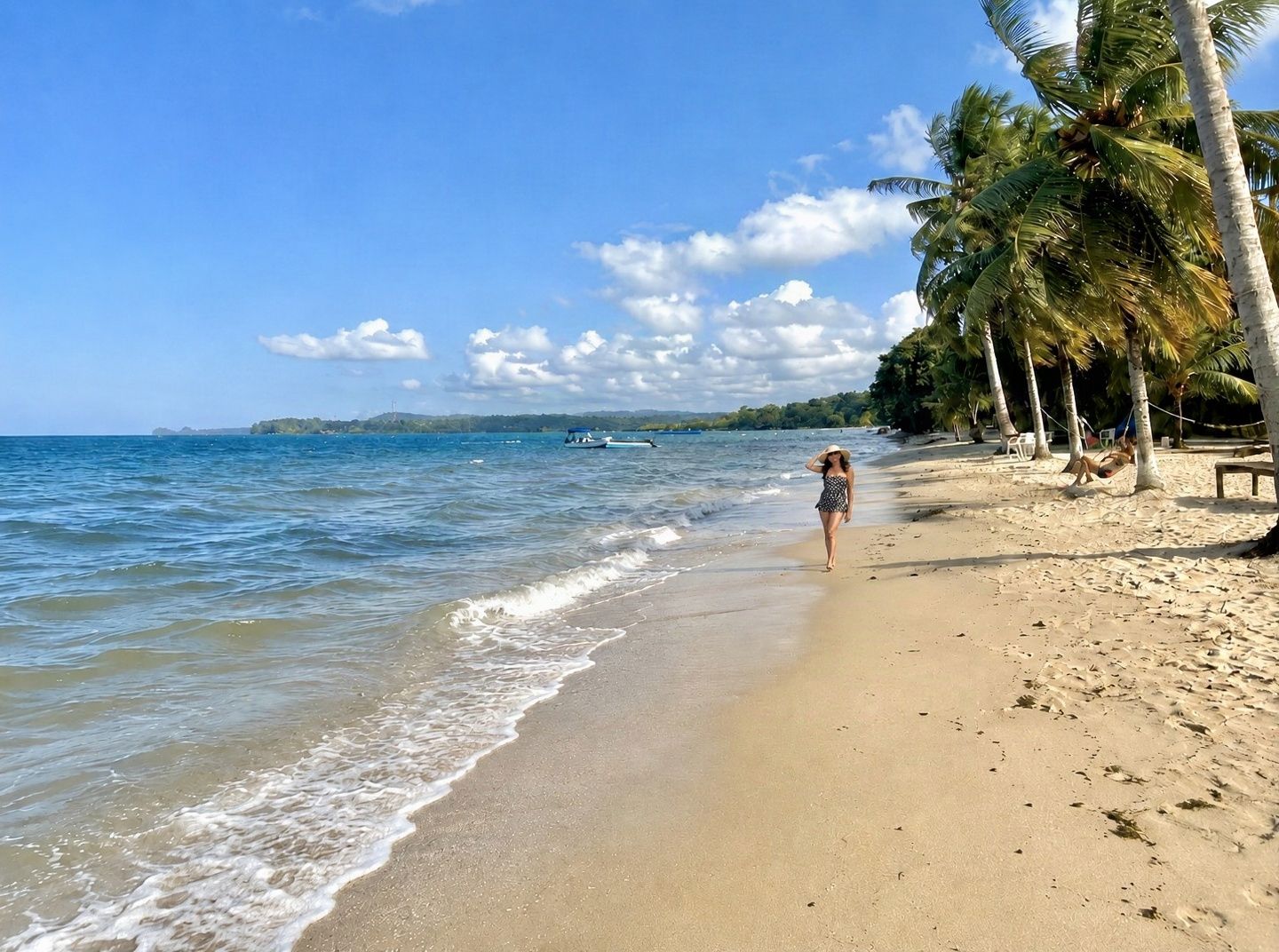 Tropical beach in Livingston with golden sand, turquoise waters and palm trees on the Garifuna coast of Izabal, Guatemala
